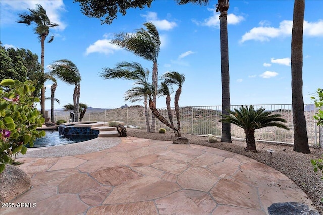 view of patio / terrace featuring a pool with connected hot tub and a fenced backyard