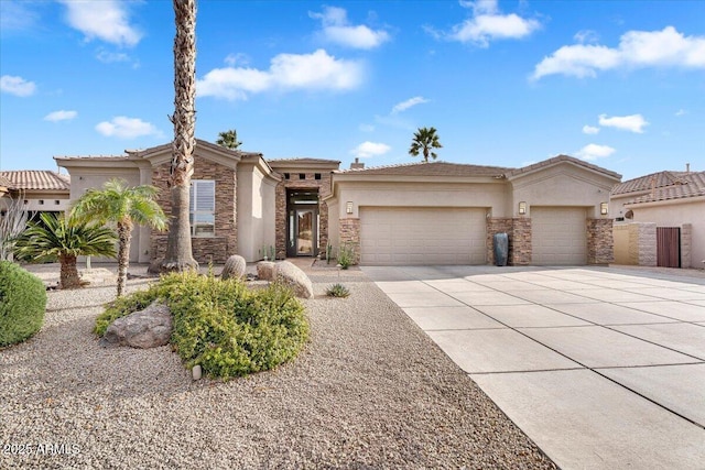 view of front facade with a tiled roof, stucco siding, driveway, stone siding, and an attached garage