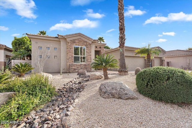 view of front of property with an attached garage, stone siding, and stucco siding