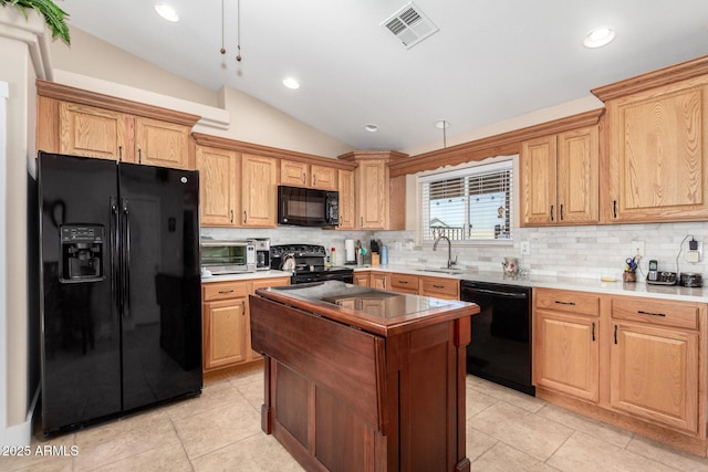 kitchen with sink, light tile patterned floors, backsplash, black appliances, and vaulted ceiling