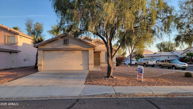 view of front of home with an attached garage, driveway, a tile roof, and stucco siding