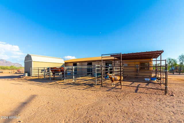 view of horse barn with a rural view