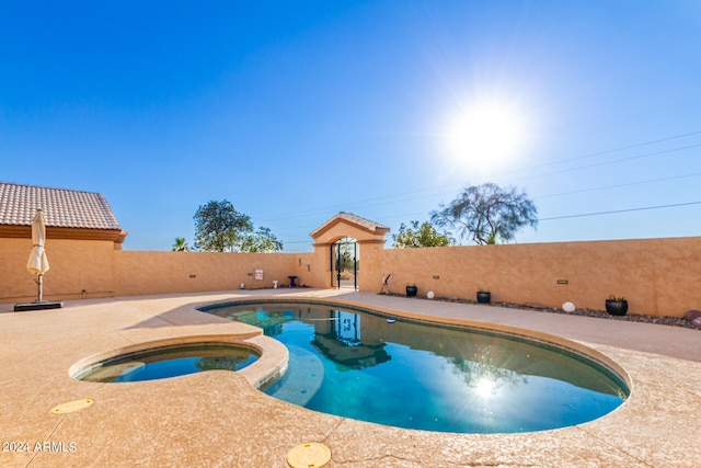 view of pool with a patio and an in ground hot tub