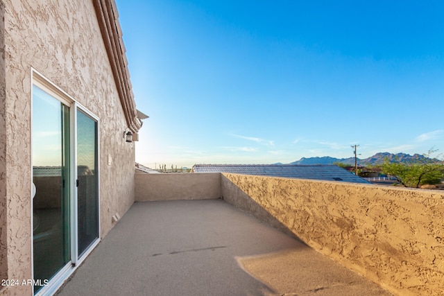 view of patio with a balcony and a mountain view