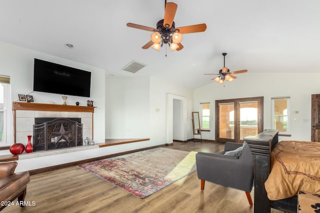 living room with ceiling fan, a fireplace, vaulted ceiling, and hardwood / wood-style floors