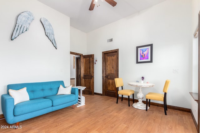 living room featuring high vaulted ceiling, ceiling fan, and wood-type flooring