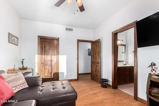 living room with sink, light wood-type flooring, and ceiling fan