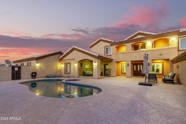 pool at dusk featuring a patio area