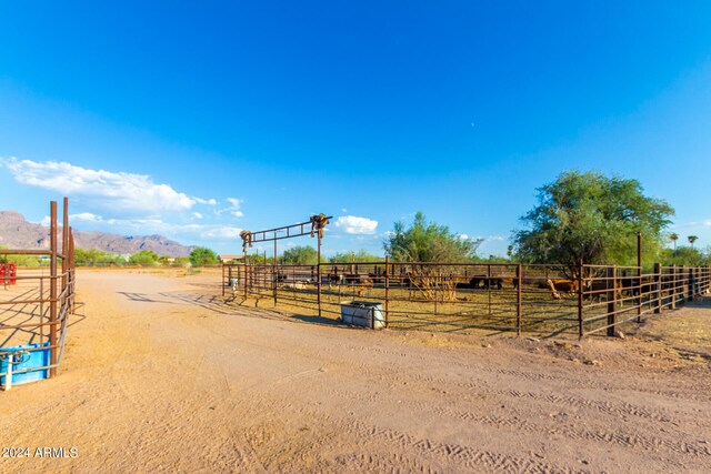 view of playground featuring a mountain view, a rural view, and an outbuilding