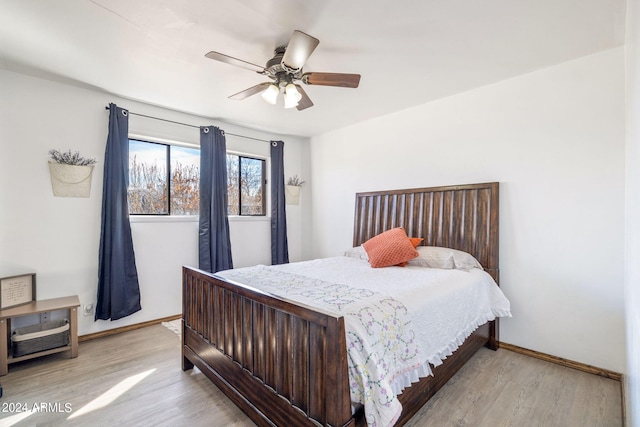 bedroom featuring light wood finished floors, a ceiling fan, and baseboards