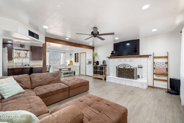 living area featuring recessed lighting, a fireplace, a ceiling fan, visible vents, and light wood-type flooring