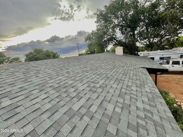 exterior details featuring a shingled roof and a chimney