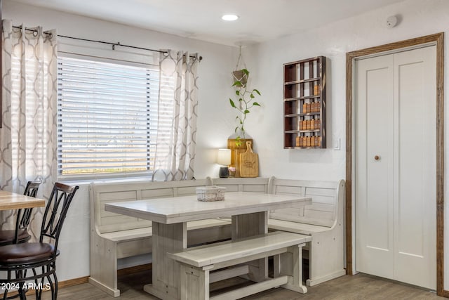 dining area featuring breakfast area, baseboards, and light wood finished floors