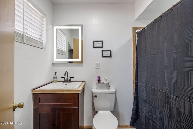 bathroom with toilet, a shower with shower curtain, and vanity