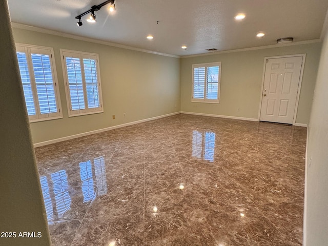 empty room with ornamental molding and track lighting