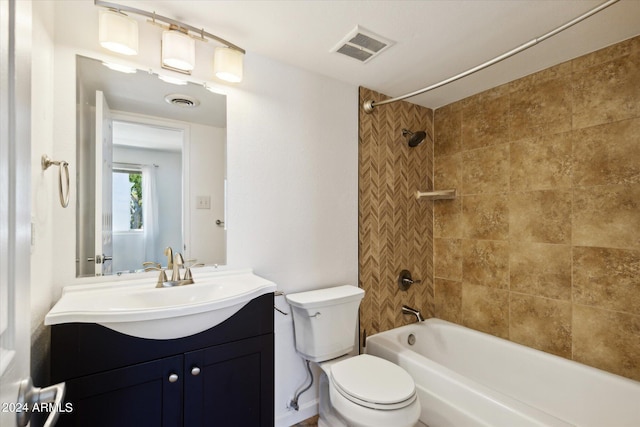 full bathroom featuring tiled shower / bath, toilet, and vanity