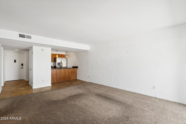 unfurnished living room with dark carpet