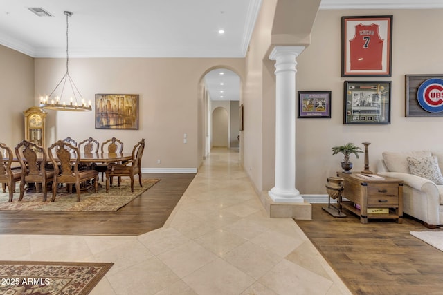 tiled dining area featuring ornamental molding, a chandelier, and decorative columns