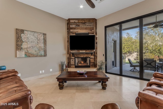 living room featuring light tile patterned floors, a stone fireplace, and ceiling fan