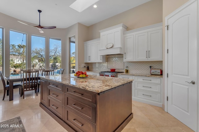 kitchen featuring white cabinetry, light stone counters, and tasteful backsplash