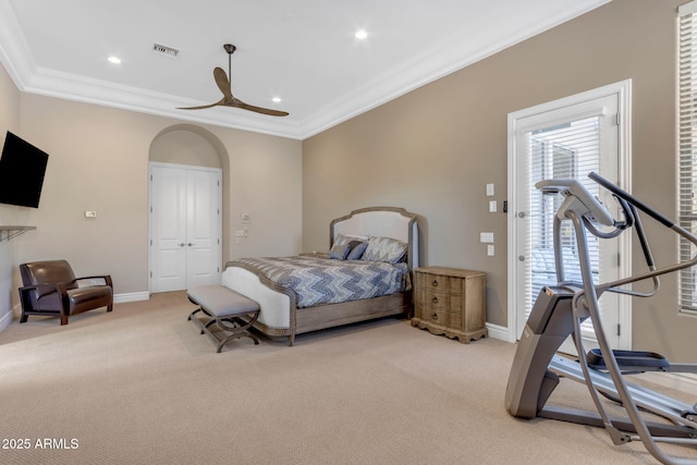 carpeted bedroom featuring crown molding, ceiling fan, and a closet