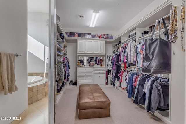 walk in closet featuring light colored carpet