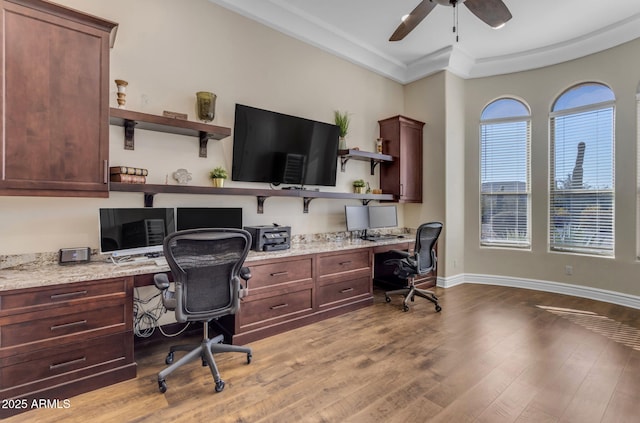 home office with crown molding, ceiling fan, built in desk, and light wood-type flooring