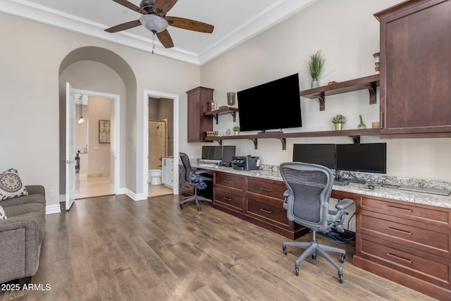 office featuring wood-type flooring, ornamental molding, built in desk, and ceiling fan