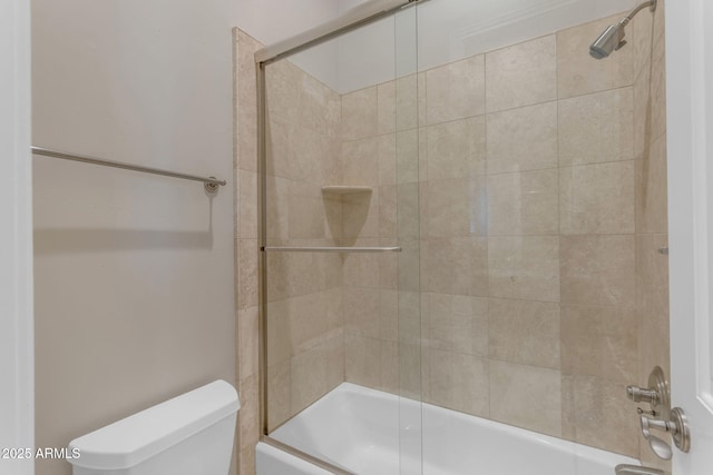 bathroom with shower / bath combination with glass door and toilet