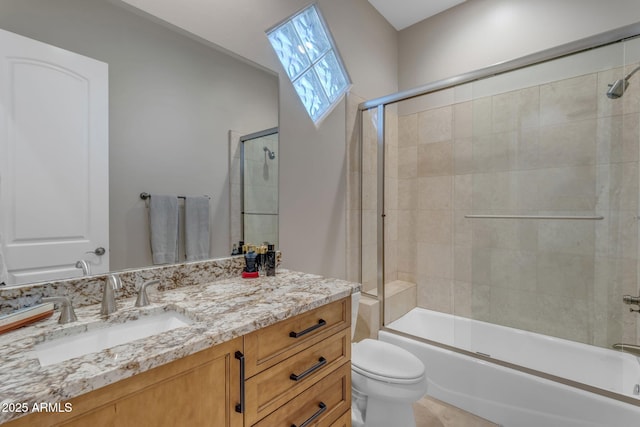 full bathroom featuring vanity, combined bath / shower with glass door, and toilet