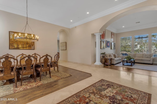 dining room with an inviting chandelier, crown molding, and ornate columns