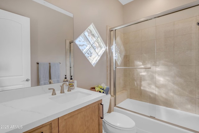 full bathroom with bath / shower combo with glass door, vanity, and toilet