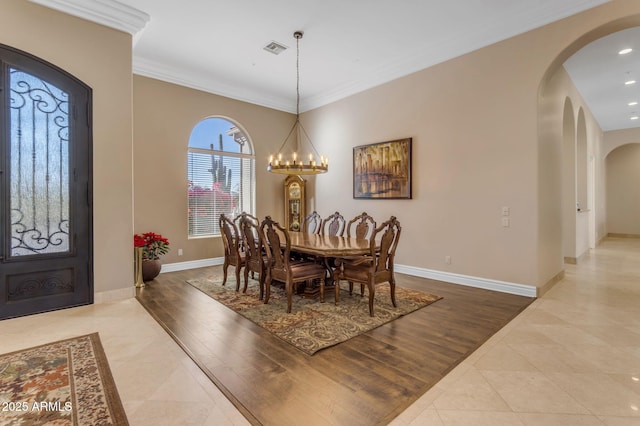 dining space with an inviting chandelier, wood-type flooring, and ornamental molding