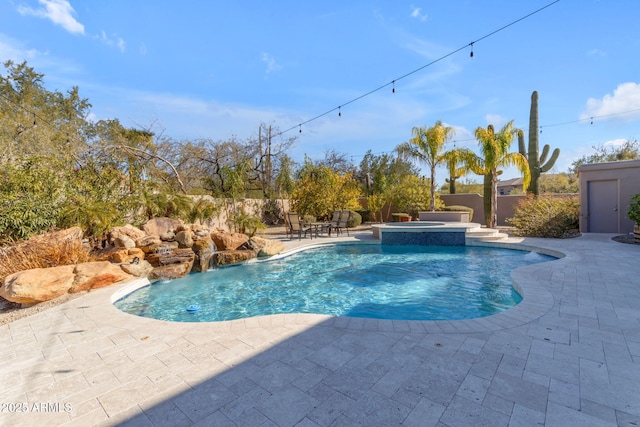 view of pool with an in ground hot tub, pool water feature, and a patio area