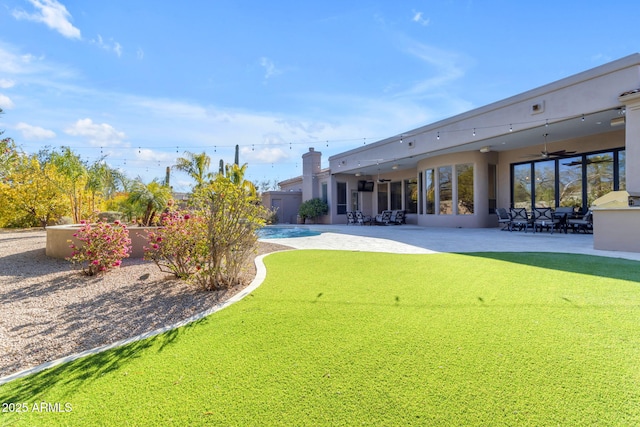 view of yard featuring a patio area and ceiling fan