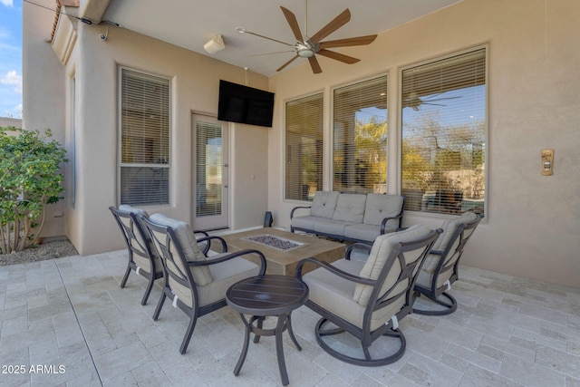 view of patio / terrace with an outdoor living space with a fire pit and ceiling fan