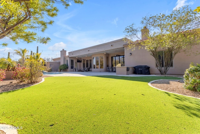 back of property featuring a yard and a patio