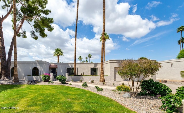view of front of home featuring an attached garage, a front lawn, and stucco siding