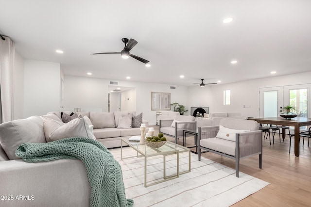 living room with a ceiling fan, light wood finished floors, and recessed lighting