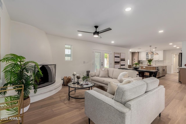 living area featuring light wood-style floors, recessed lighting, and ceiling fan