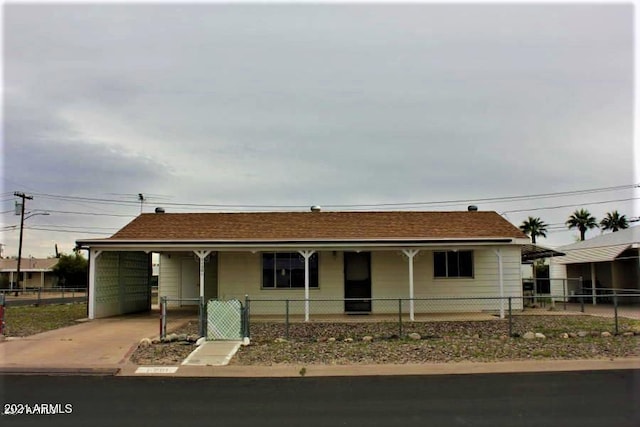 11201 W Missouri Ave, Youngtown, AZ 85363 - ranch-style house featuring a porch, concrete driveway, a fenced front yard, and a carport