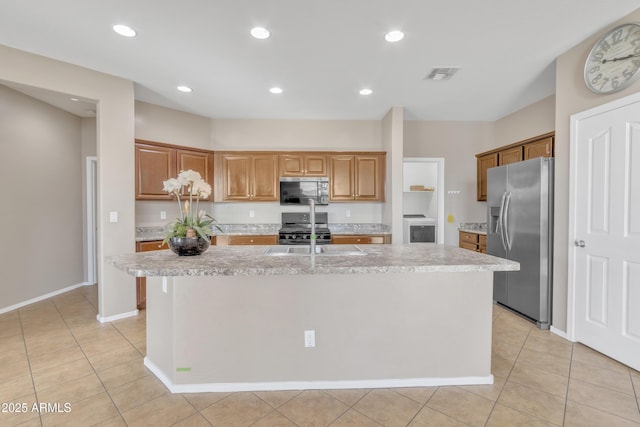 kitchen featuring light tile patterned flooring, sink, a kitchen island with sink, stainless steel fridge with ice dispenser, and black range with gas cooktop