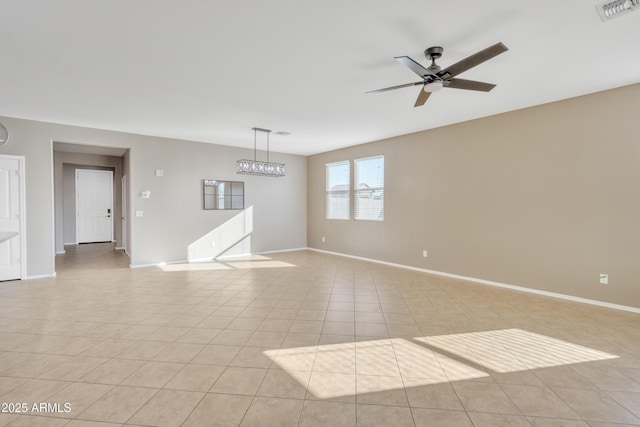 unfurnished room with light tile patterned flooring and ceiling fan with notable chandelier