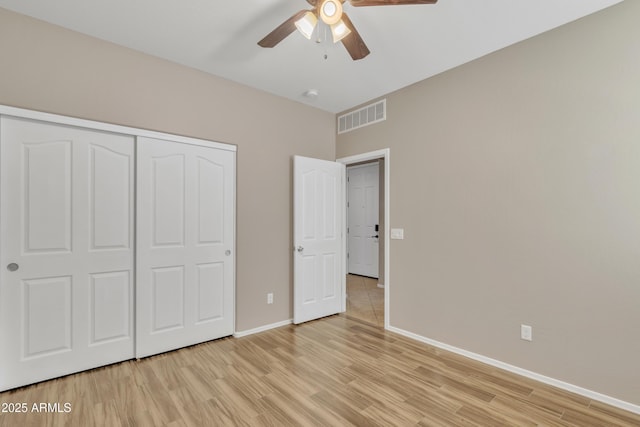 unfurnished bedroom with light hardwood / wood-style flooring, a closet, and ceiling fan