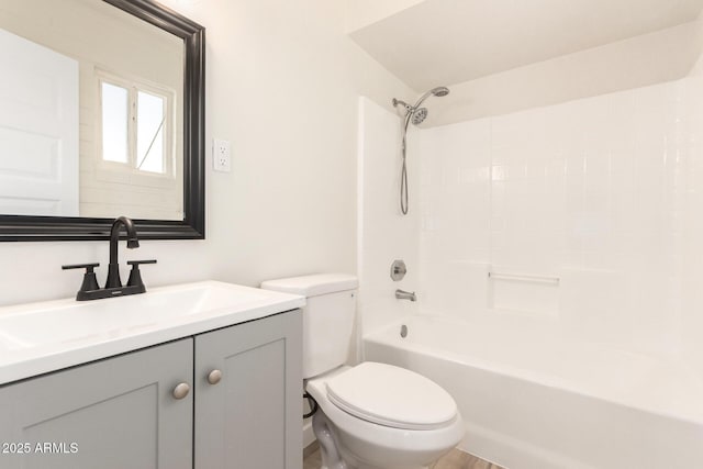 bathroom with bathtub / shower combination, vanity, and toilet