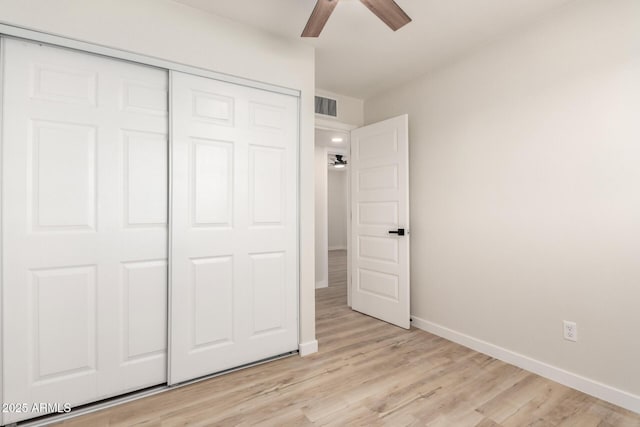 unfurnished bedroom featuring a closet, visible vents, light wood-style flooring, and baseboards