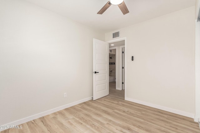 unfurnished room with baseboards, visible vents, a ceiling fan, and light wood-style floors