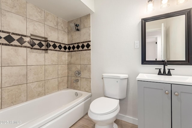 bathroom featuring shower / bathing tub combination, toilet, vanity, wood finished floors, and baseboards