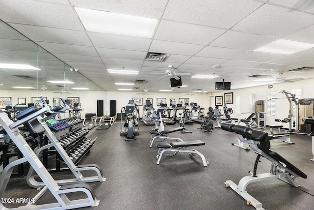 workout area with a paneled ceiling and ceiling fan