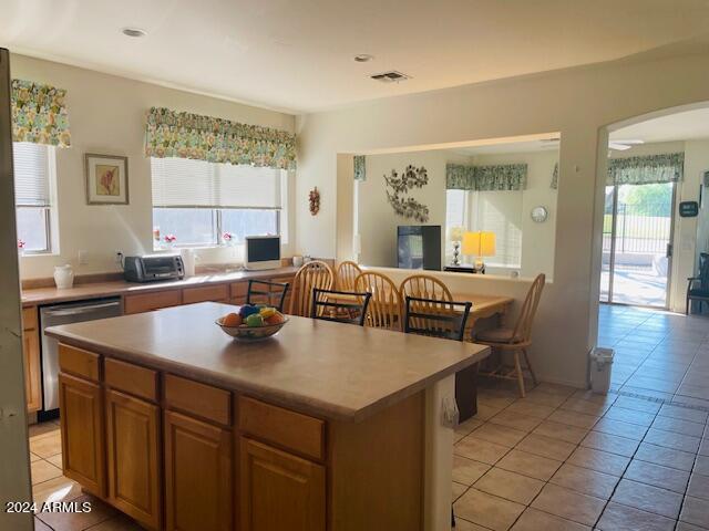 kitchen with plenty of natural light, a kitchen island, visible vents, and stainless steel dishwasher